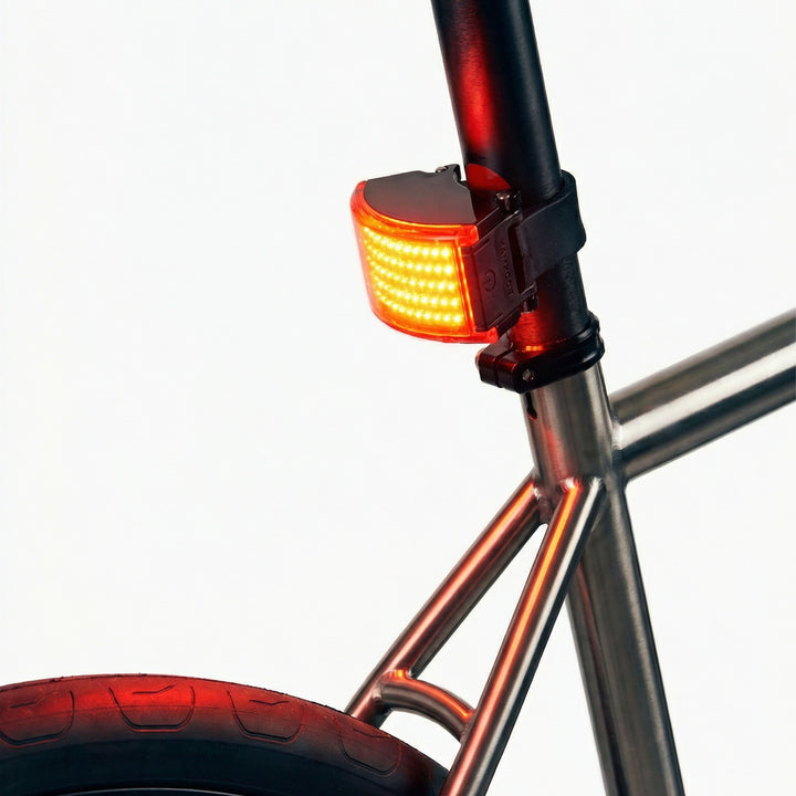 Bicycle tail light attached to a bike frame with a white background #color_black